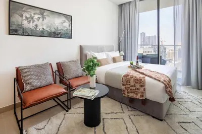 a hotel room with a bed and two chairs at Frank Porter - Binghatti Azure in Dubai