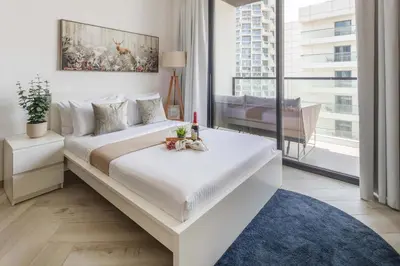 a bedroom with a large white bed with a window at Frank Porter - Empire Residence, JVC in Dubai