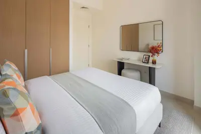 a bedroom with a bed with a desk and a mirror at Frank Porter - Lotus at Creek Beach in Dubai