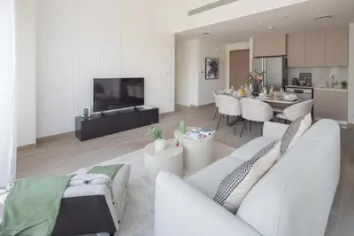 a living room with white furniture and a kitchen at Frank Porter - Lotus at Creek Beach in Dubai