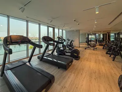 a gym with several treadmills and exercise bikes at Frank Porter - Canal Front Residence 9A in Dubai