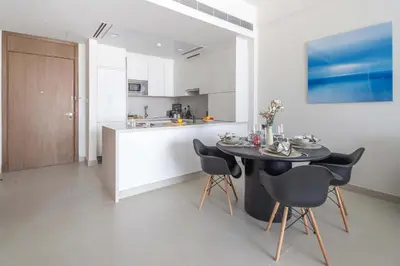 a kitchen with a table and chairs in a room at Frank Porter - Canal Front Residence 9A in Dubai