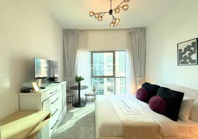 a bedroom with a bed and a dresser and a window at Boulevard Charm- Studio Hideaway in Dubai