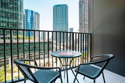 a balcony with a table and chairs and a view of a city at FIRST CLASS Studio Modern Elegance in Dubai