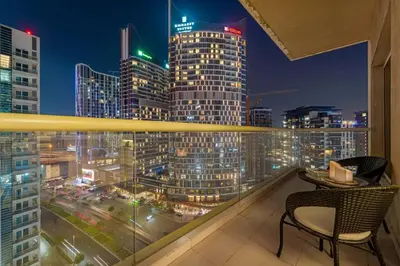 a balcony with a view of a city at night at FIRST CLASS 1BR Canal Views , Gem of Mayfair in Dubai