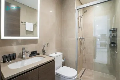 a bathroom with a toilet and a sink and a shower at Blue Breeze - 2 Bedroom near Downtown, Elegant Retreat in Sobha in Dubai