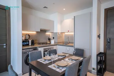 a kitchen with a dining room table and chairs at Blue Breeze - 2 Bedroom near Downtown, Elegant Retreat in Sobha in Dubai