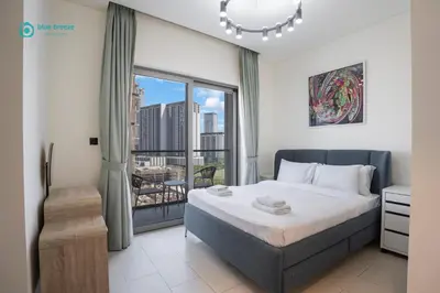 a bedroom with a bed and a large window at Blue Breeze - 2 Bedroom near Downtown, Elegant Retreat in Sobha in Dubai