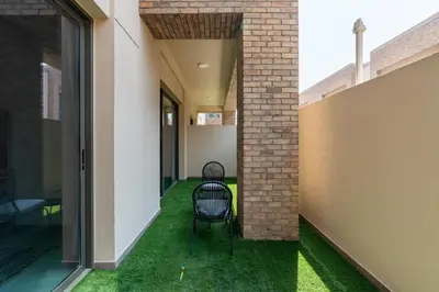 an internal courtyard of a house with green grass at Ahlan HH - 1BR Haven with Study Room - Eleganz by Danube in Dubai