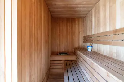 a sauna with wooden walls and a wooden bench at Ahlan HH - 1BR Haven with Study Room - Eleganz by Danube in Dubai