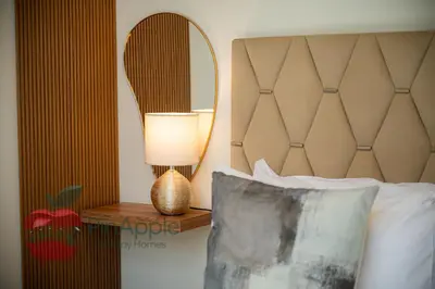 a bedroom with a bed with a lamp and a mirror at Beautiful1BR Close to Downtown in Dubai