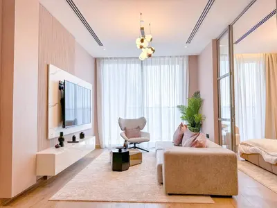 a living room with a couch and a tv at 1BDR with Gym, Sauna, Pool - Opposite Circle Mall in Dubai