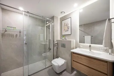 a bathroom with a shower and a toilet and a sink at Panoramic Fountain & Burj Khalifa Views, Pool, Gym in Dubai