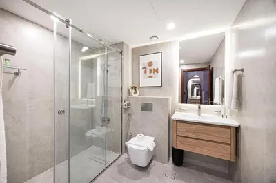 a bathroom with a shower and a toilet and a sink at Panoramic Fountain & Burj Khalifa Views, Pool, Gym in Dubai