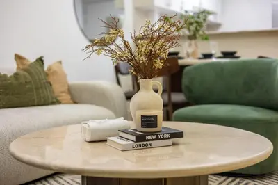 a coffee table with books and a vase on top at ShoresInn -Waterfront Bliss in Dubai Marina in Dubai