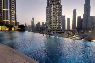 a large swimming pool in a city with tall buildings at Vacationer I Luxury 2 Bedroom I Burj Khalifa View in Dubai