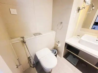 a white bathroom with a toilet and a sink at Elegant Urban Escape in Dubai