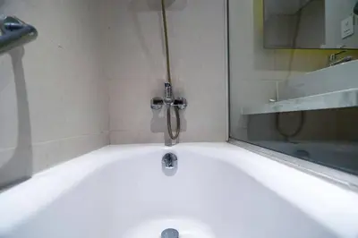 a bath tub with a faucet in a bathroom at Elegant Urban Escape in Dubai