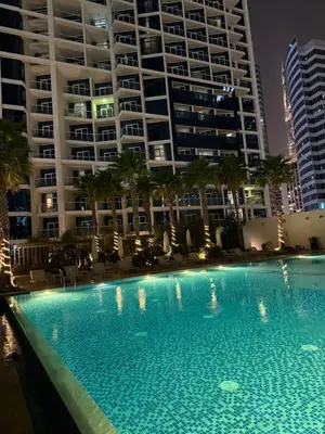 a large swimming pool in front of a large building at Studio With Canal View in Dubai