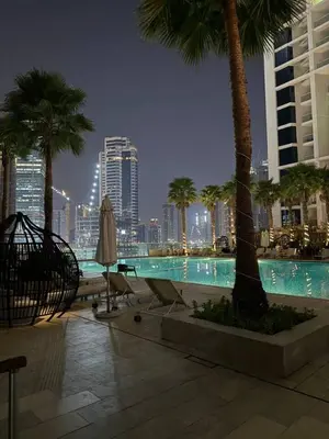 a swimming pool with palm trees and a city skyline at Studio With Canal View in Dubai