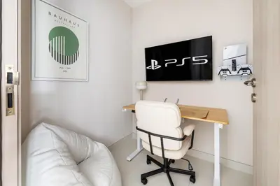 a room with a desk and a white chair at Stylish 1BR with PS5, Sauna and Kids' Play Area in Dubai