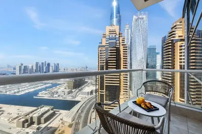 a balcony with a table and chairs and a view of a city at Marina 2BR with 31st-Floor Ocean View in Dubai