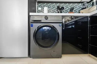 a washing machine in a kitchen next to a counter at Marina 2BR with 31st-Floor Ocean View in Dubai