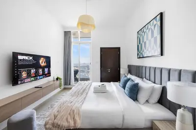 a bedroom with a large bed and a tv at Marina 2BR with 31st-Floor Ocean View in Dubai