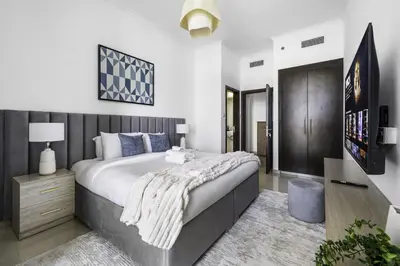 a bedroom with a large bed and a television at Marina 2BR with 31st-Floor Ocean View in Dubai