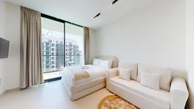 a living room with a couch and a large window at Vacationer l Bright, Modern Studio Retreat l Free Gym, Pool Access in Dubai