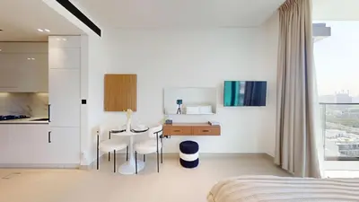 a bedroom with a desk and a table and chairs at Vacationer l Bright, Modern Studio Retreat l Free Gym, Pool Access in Dubai