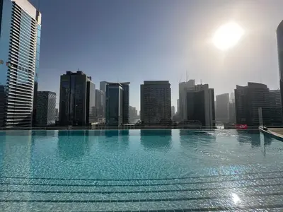 a large swimming pool in front of a city skyline at IMPERIAL AVENUE Brand New Ultra Luxury Full Downtown, Old Town & Burj Khalifa Amazing View! Unforgettable Stay! in Dubai