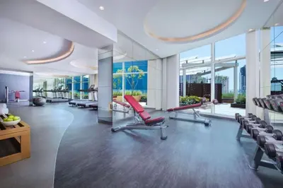 a large room with a gym with chairs and windows at Maison Privee - Dazzling Downtown Retreat with Panoramic City Views in Dubai