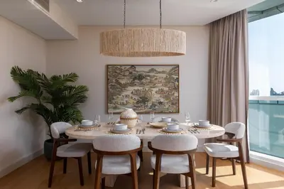 a dining room with a table and chairs and a painting at Maison Privee - Dazzling Downtown Retreat with Panoramic City Views in Dubai