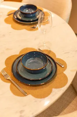 a table with two plates and a wine glass at Luxury Stay - Dubai Creek Harbour - Branded Living - Burj View in Dubai