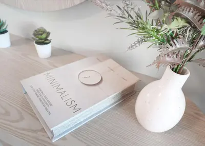 a book sitting on a table next to a vase at Brand New Studio for 4 Guests - Near Dubai Mall in Dubai