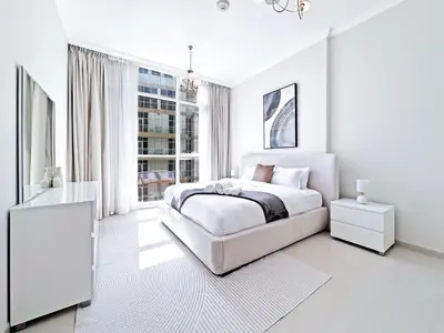 a white bedroom with a bed and a window at Luxury Stay in Downtown Dubai -Burj Khalifa in Dubai