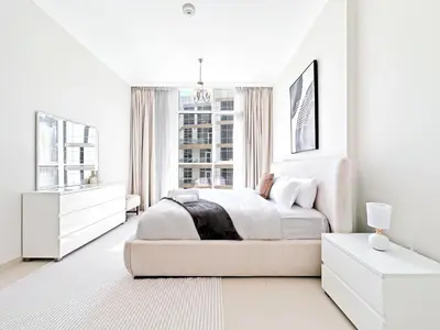 a white bedroom with a large bed and a window at Luxury Stay in Downtown Dubai -Burj Khalifa in Dubai