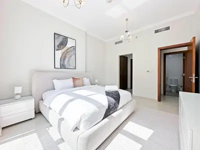 a white bedroom with a large bed and a bathroom at Luxury Stay in Downtown Dubai -Burj Khalifa in Dubai