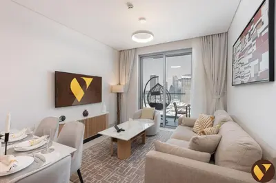 a living room with a couch and a table at Vogue Downtown Vida Dubai Mall, Direct Access to Dubai Mall via Climate Controlled bridge, Two Bedroom Apartment with Full Burj Khalifa View from Balcony and Access to all Amenities in Dubai