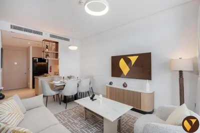 a living room with a couch and a table at Vogue Downtown Vida Dubai Mall, Direct Access to Dubai Mall via Climate Controlled bridge, Two Bedroom Apartment with Full Burj Khalifa View from Balcony and Access to all Amenities in Dubai
