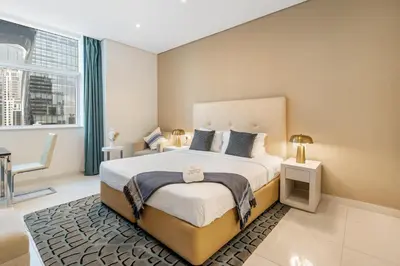 a bedroom with a large bed and a window at DAMAC Maison Cour Jardin in Dubai