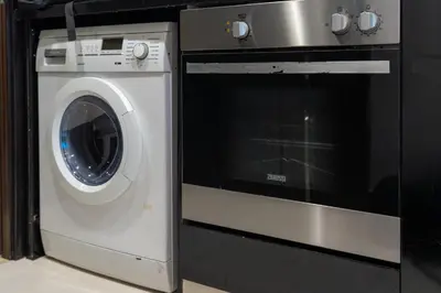a washer and a washing machine in a kitchen at DAMAC Maison Cour Jardin in Dubai