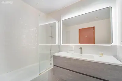 a white bathroom with a sink and a shower at 4BR Spacious Apartment in Sadaf 8 JBR, 3 Min Walk To The Beach With Sea and Dubai Marina View in Dubai