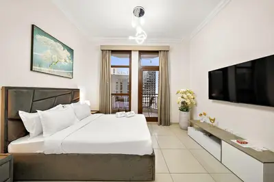 a bedroom with a large bed and a television at FIRST CLASS High End Studio near Miracle Garden in Dubai
