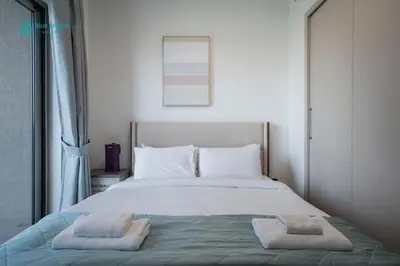 a bedroom with a bed with two towels on it at Blue Breeze - Luxury 2BR in Sobha Creek Vistas Near Downtown in Dubai