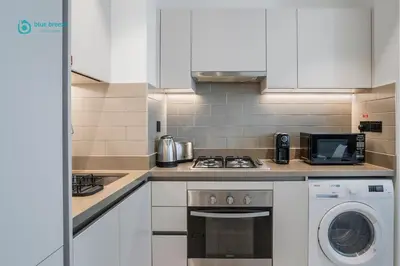 a kitchen with a stove top oven next to a microwave at Blue Breeze - Luxury 2BR in Sobha Creek Vistas Near Downtown in Dubai