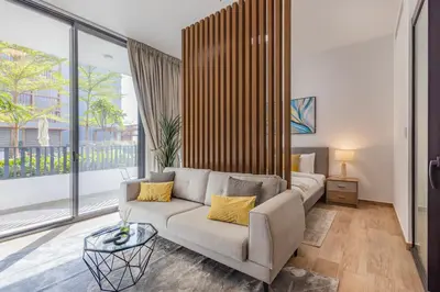a living room with a couch and a large window at Hamilton House, JVC - 1 Bedroom Apartment - Allsopp & Allsopp in Dubai