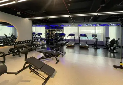 a gym with several treadmills and exercise bikes at Hamilton House, JVC - 1 Bedroom Apartment - Allsopp & Allsopp in Dubai