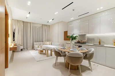 a kitchen and living room with a table and chairs at FIRST CLASS 1BR Luxurious JVC Blissful Escape in Dubai